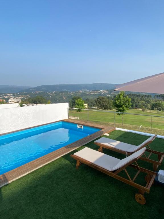 una piscina con 2 tumbonas junto a ella en Moradia - Vila Golfe Amarante en Amarante