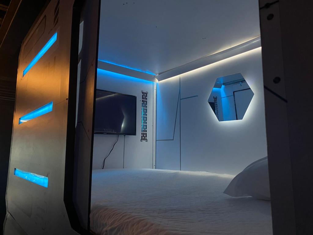 Habitación con cama con luces azules. en Hotel Hostal Caps San Diego, en Medellín