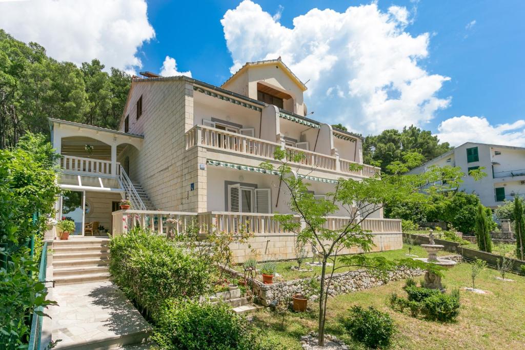 uma grande casa branca com uma varanda em Apartments by the sea Brela, Makarska - 18356 em Brela