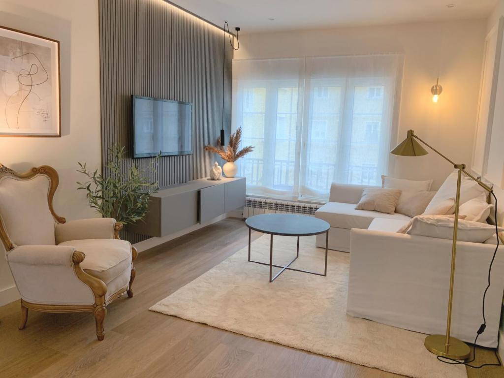 ein Wohnzimmer mit einem Sofa und einem Tisch in der Unterkunft Lujoso apartamento boutique a estrenar con parking gratis in Gijón
