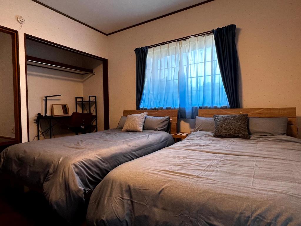 1 Schlafzimmer mit 2 Betten und einem Fenster in der Unterkunft 奄美大島の一棟貸切のヴィラAmalog アマログ in Akaoki