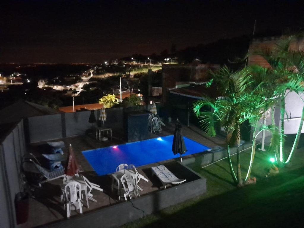 uma vista para uma piscina à noite em RECANTO K9 - SERRA NEGRA SP. No verão e no inverno em Serra Negra