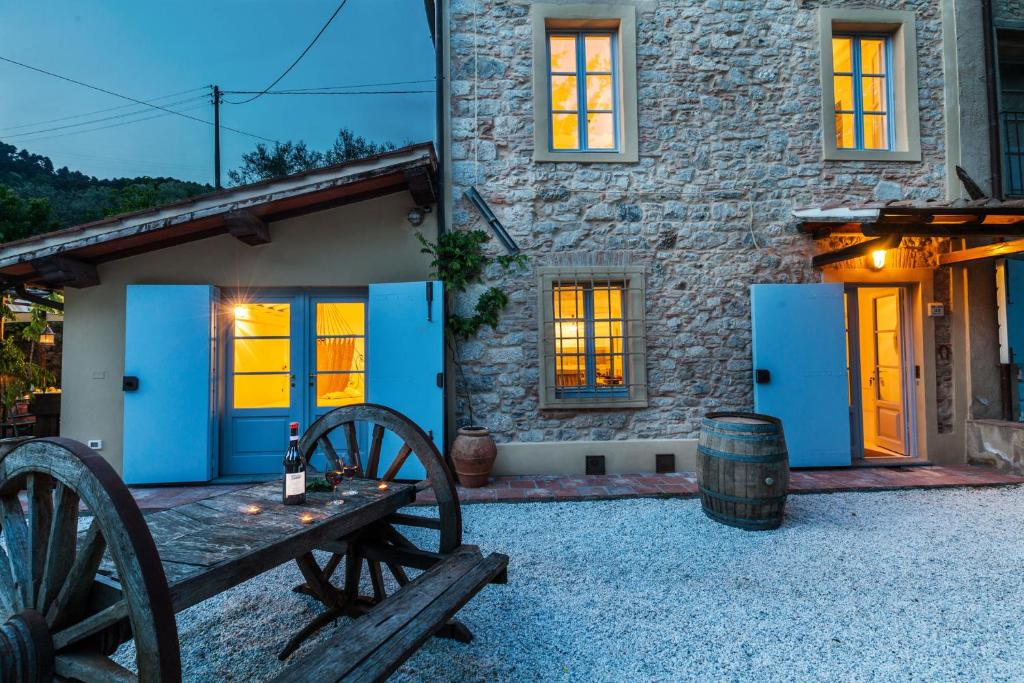 kamienny dom z niebieskimi drzwiami i drewnianym stołem w obiekcie Smart Appart Tuscany w mieście Fibbialla