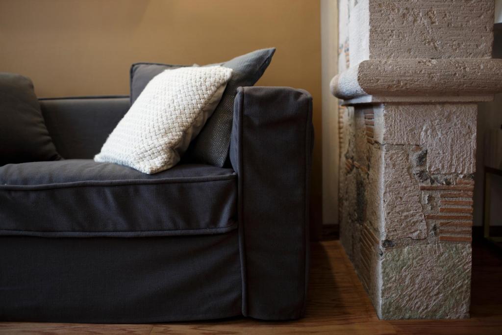 a couch with a pillow on it next to a wall at Maja Hotel Boutique in Morelia
