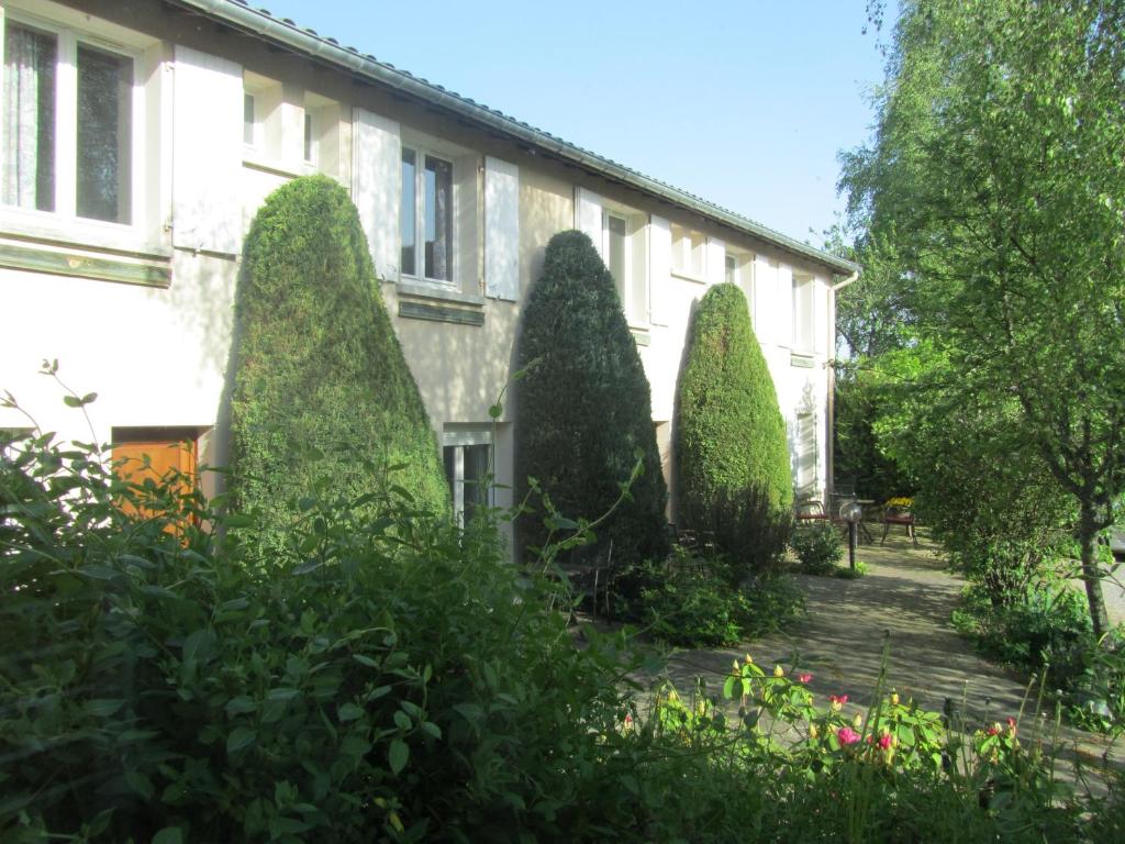 a row of trees in front of a building at Auberge de l'Arzon in Chomelix