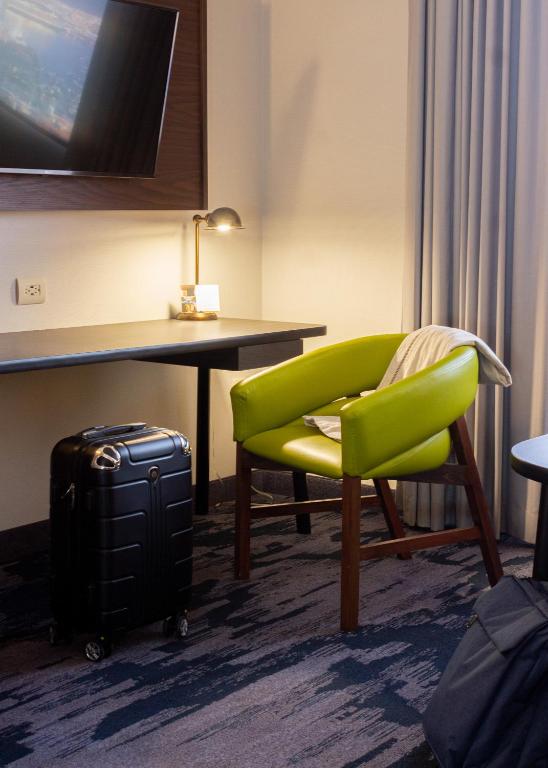 a hotel room with a green chair and a desk at Fairfield Inn & Suites by Marriott Tijuana in Tijuana