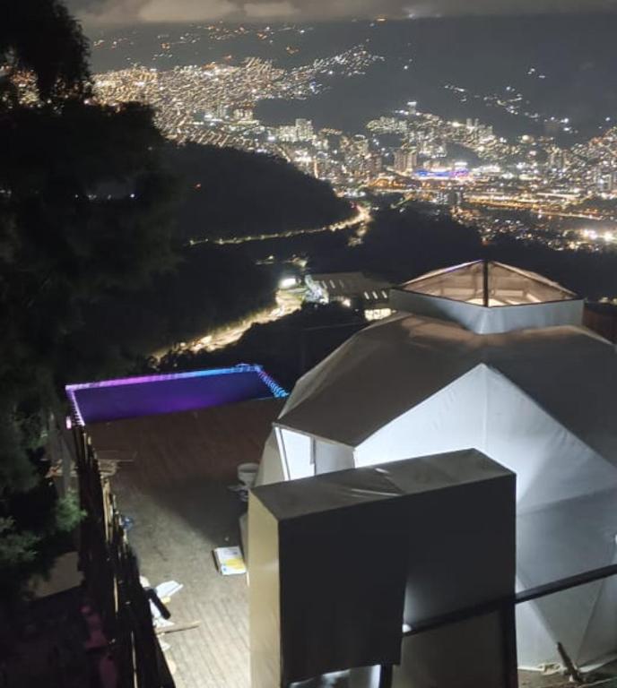 a view of a city at night from a building at Glamping ecoglam Medellín in Copacabana