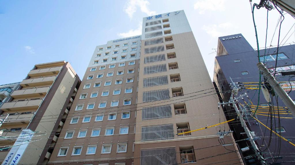 a tall building in the middle of some buildings at Toyoko Inn Kagoshima chuo eki Nishi guchi in Kagoshima