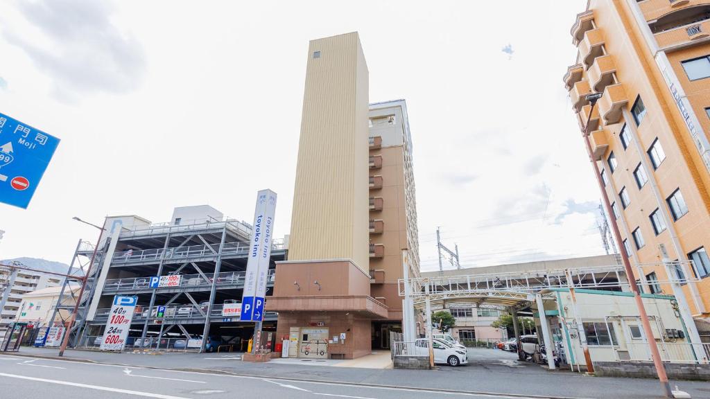 un edificio alto en una calle de la ciudad con edificios en Toyoko Inn Kokura eki Shinkansen guchi, en Kitakyushu
