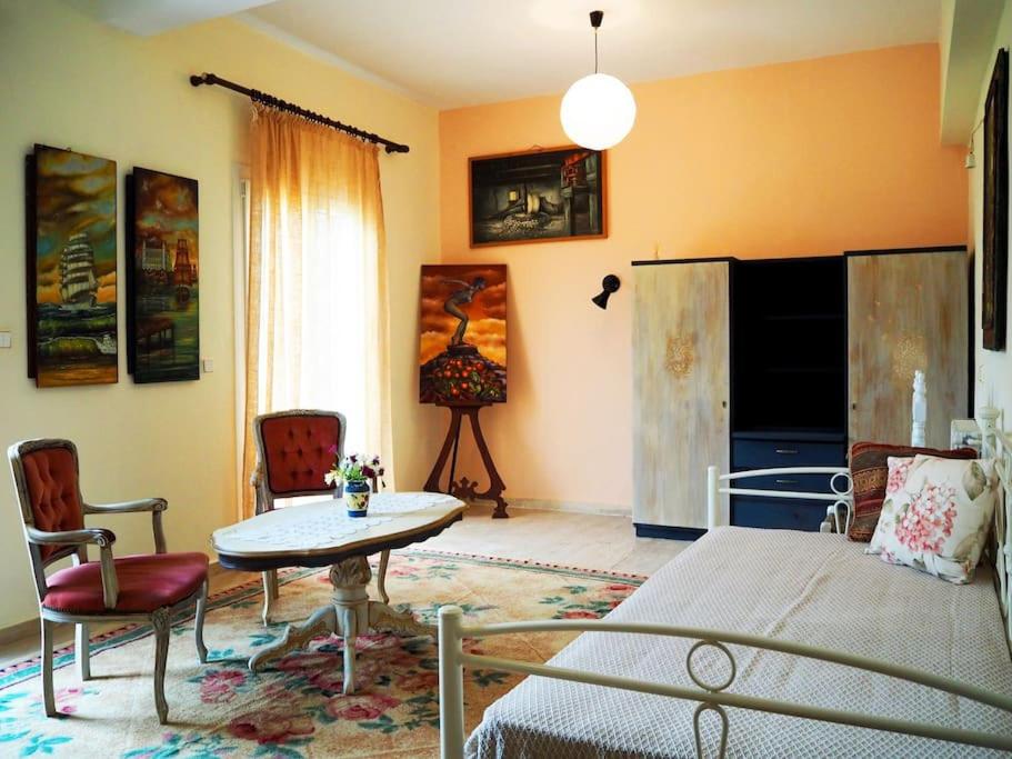 a bedroom with a bed and a table and chairs at painter's house in Agios Ioannis