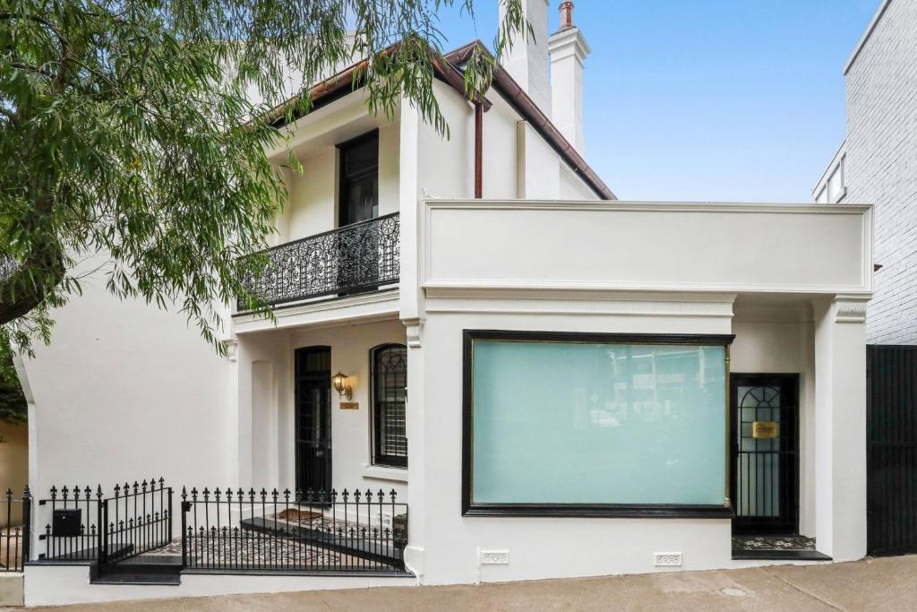 a white house with a black fence at Paddington house beautiful 2 bedroom terrace in Sydney