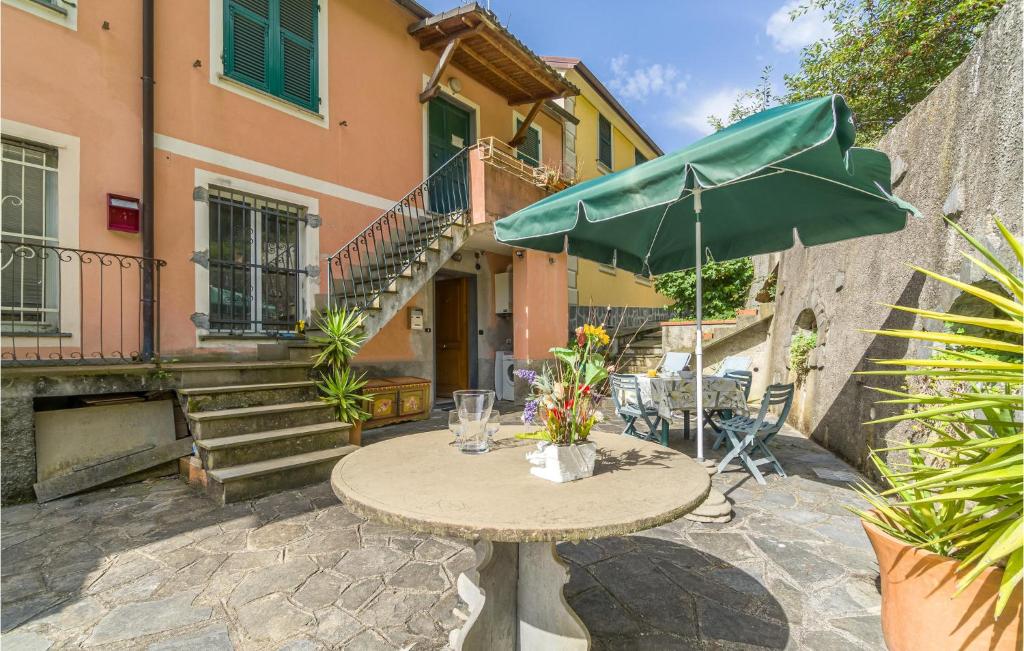 - une table avec un parasol vert sur la terrasse dans l'établissement 1 Bedroom Awesome Apartment In Uscio, à Uscio