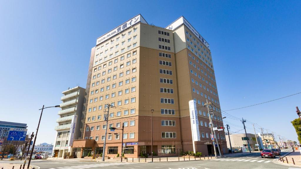 a tall building on the corner of a street at Toyoko Inn Fujisan Mishima-eki in Mishima