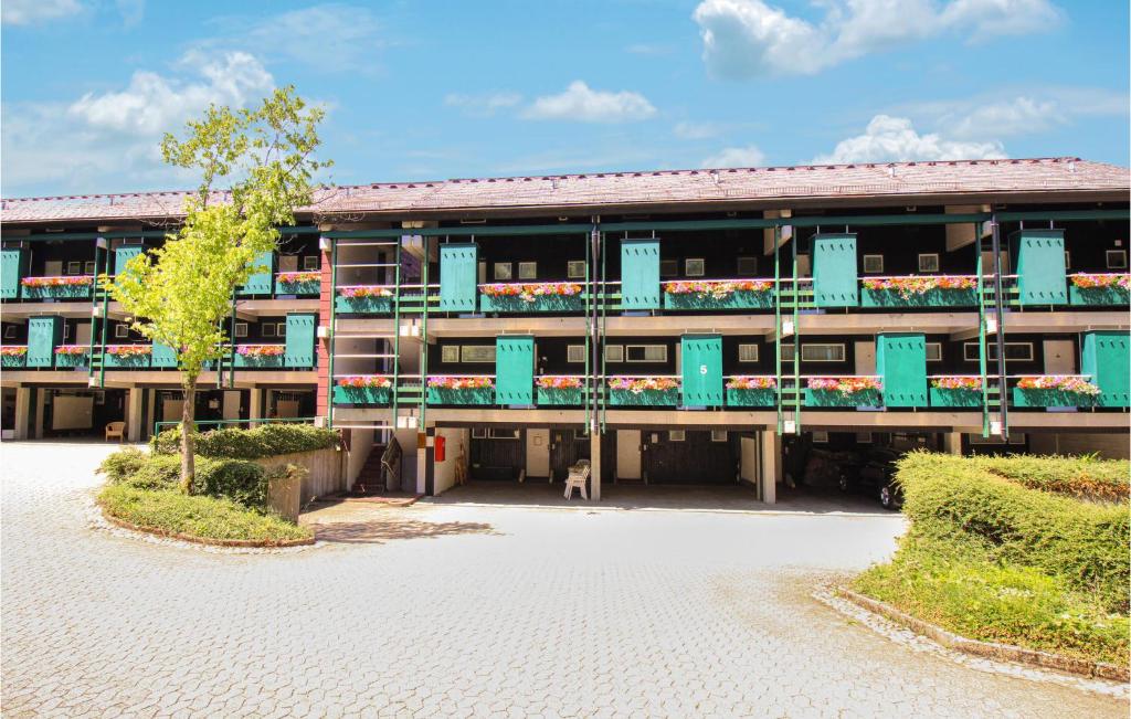 un edificio de apartamentos con balcones azules y un árbol en Stunning Apartment In Sasbachwalden With Wifi, en Sasbachwalden