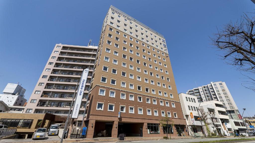 a tall building on a city street with buildings at Toyoko Inn Nagano eki Zenkoji guchi in Nagano