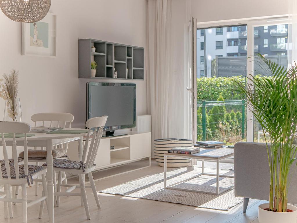 a living room with a table and a tv at CitySand Apartament in Gdańsk