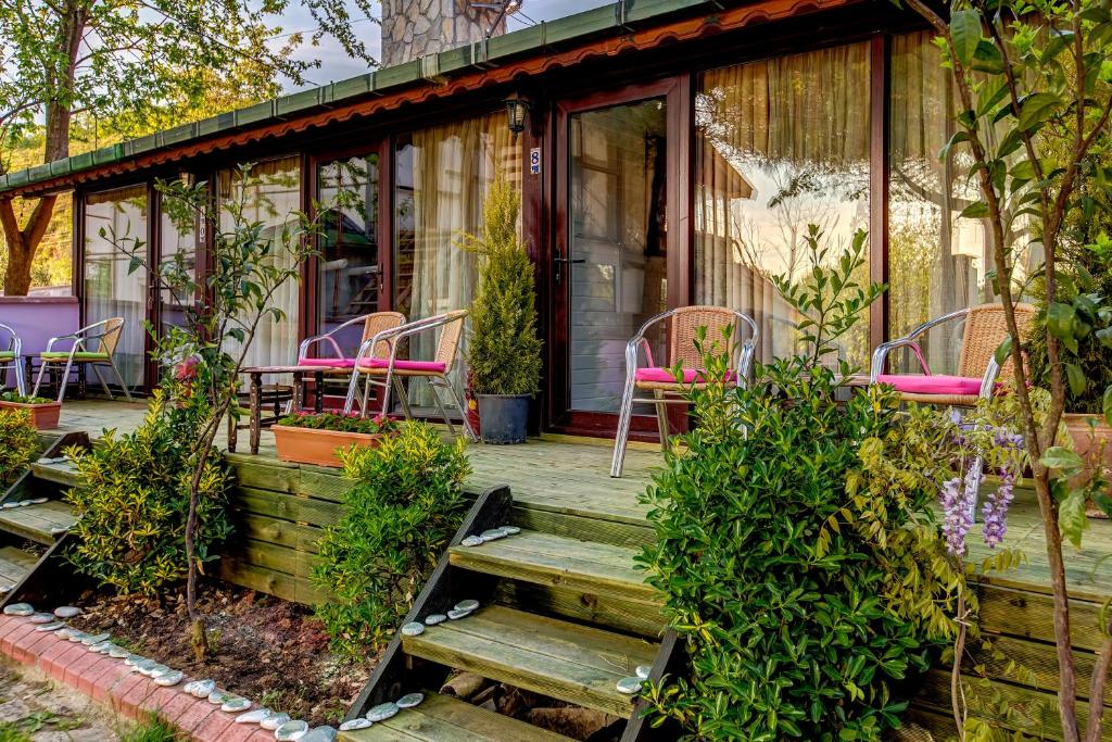a house with pink chairs and a wooden porch at Park Mandalin Hotel - Adult only in Ağva