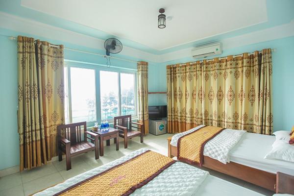 a bedroom with two beds and a window at Thành Thư Vân Đồn Hotel - by Bay Luxury in Quang Ninh