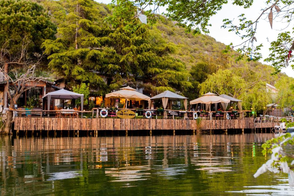a pier with tables and umbrellas on the water at Park Mandalin Hotel - Adult only in Ağva