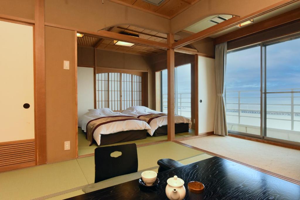 a bedroom with a bed and a view of the ocean at Kaiyutei in Kawazu