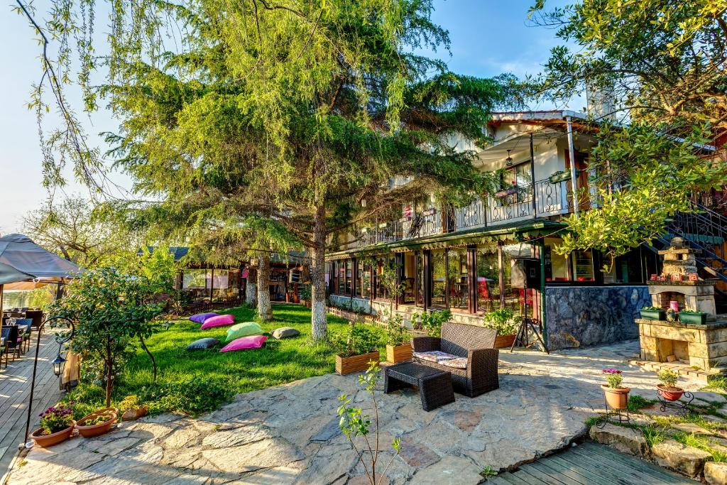 una casa con un árbol y un patio en Park Mandalin Hotel - Adult only, en Agva