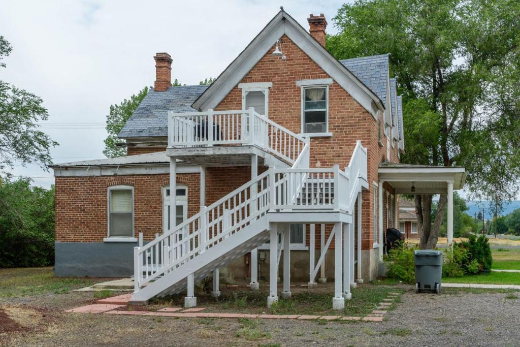 a brick house with a white staircase on it at Panguich Red Brick Homes upper Home in Panguitch