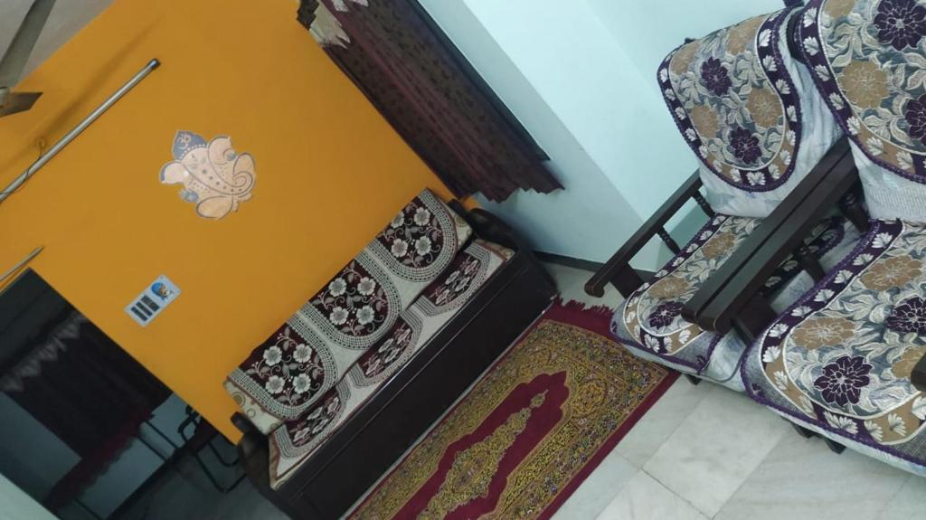 a table with a laptop on it next to two chairs at Acharyaa Homestay in Tiruchchirāppalli