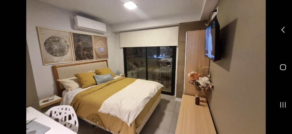 um pequeno quarto com uma cama e uma televisão em Studio ideal viaje en pareja o trabajo em San Miguel de Tucumán