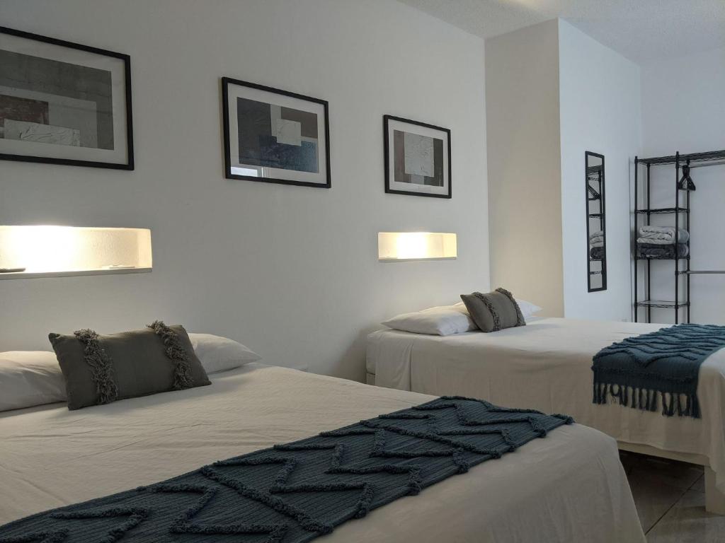 a room with two beds and two pictures on the wall at Hermoso departamento en Cancún YaxBahia 3 in Cancún