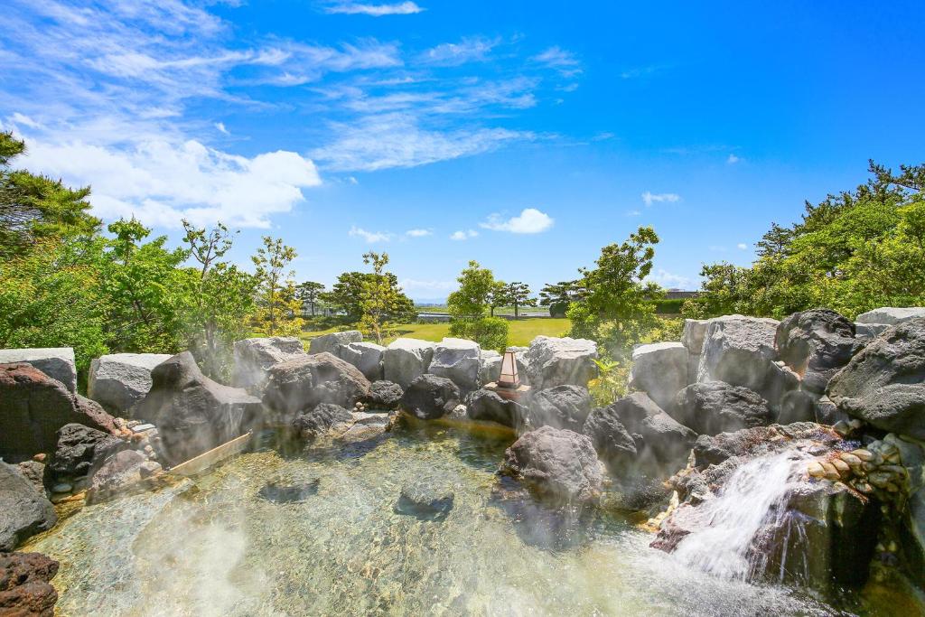 une cascade dans un zoo avec des rochers dans l'établissement Ooedo Onsen Monogatari Premium Hotel Sokan, à Matsushima