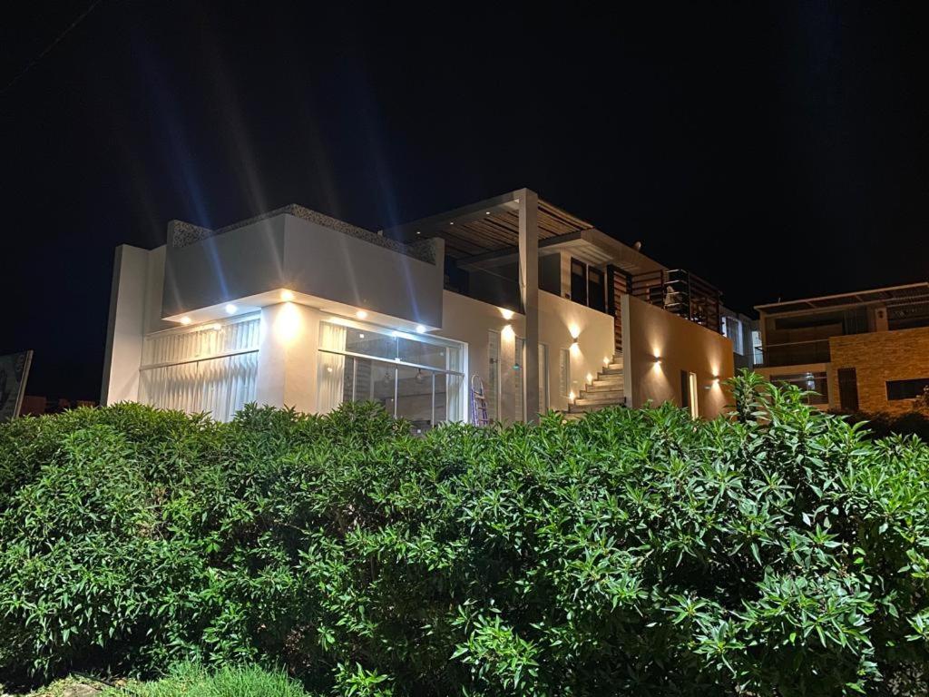 una casa con luces delante de ella por la noche en G&E_BEACH HOUSE, en Mejia