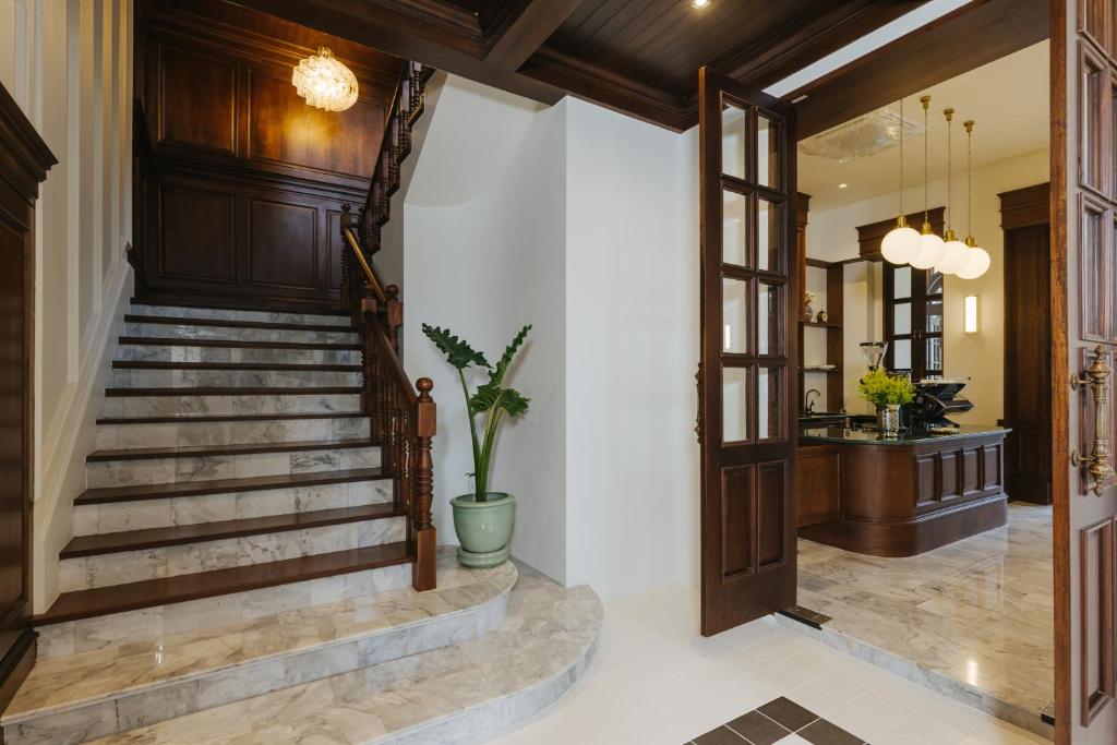 A grand marble staircase opens onto a warmly lit reception or lounge area.