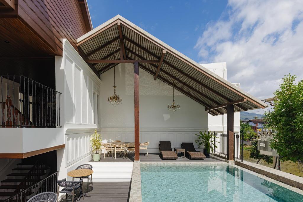 A rooftop-style pool terrace combines a long swimming pool, covered loungers and outdoor dining.
