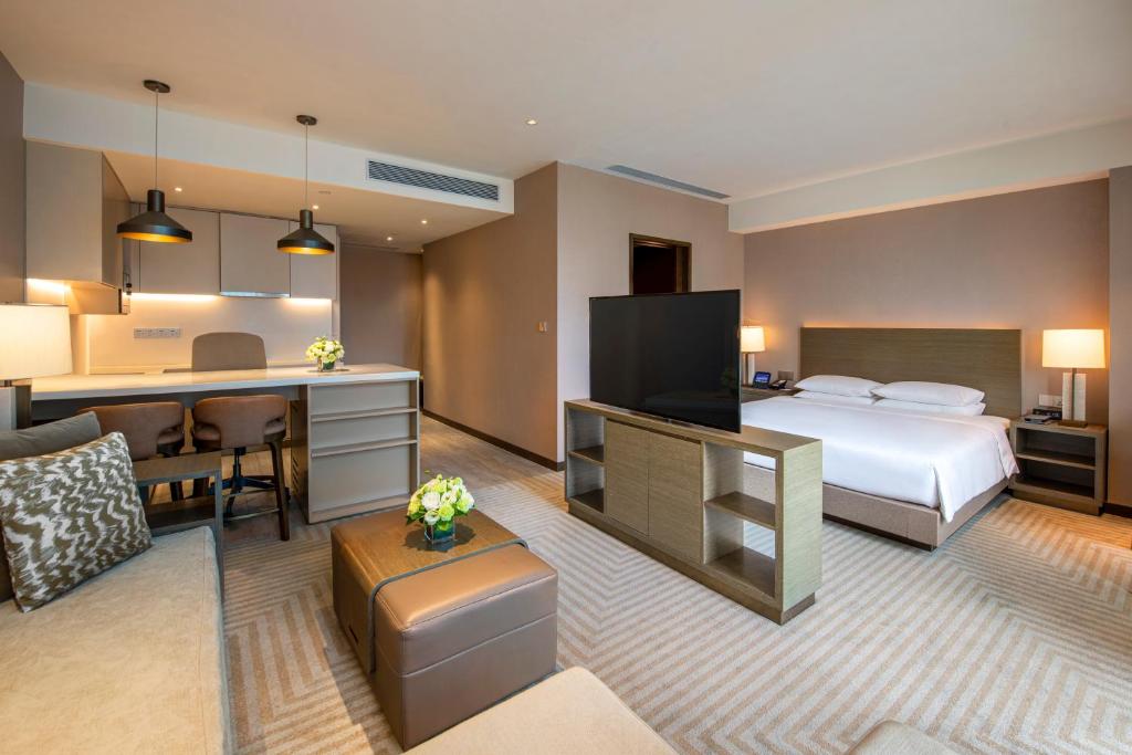 a large hotel room with a bed and a desk at Hyatt House Chengdu Pebble Walk in Chengdu