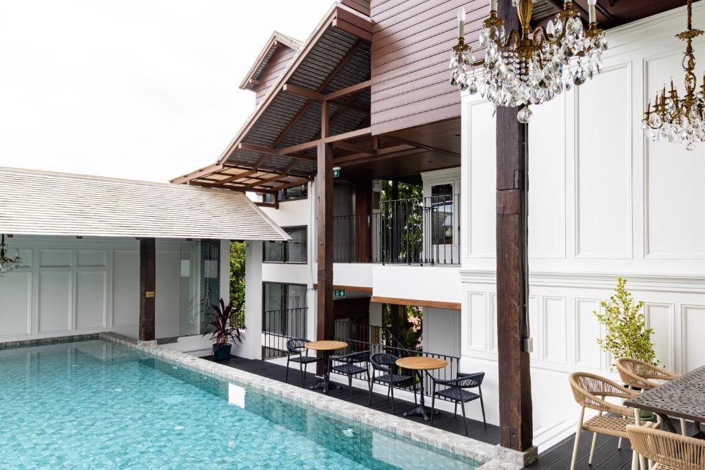 The pool courtyard pairs a narrow swimming pool with chandeliers, cafe seating and multi-level timber architecture.