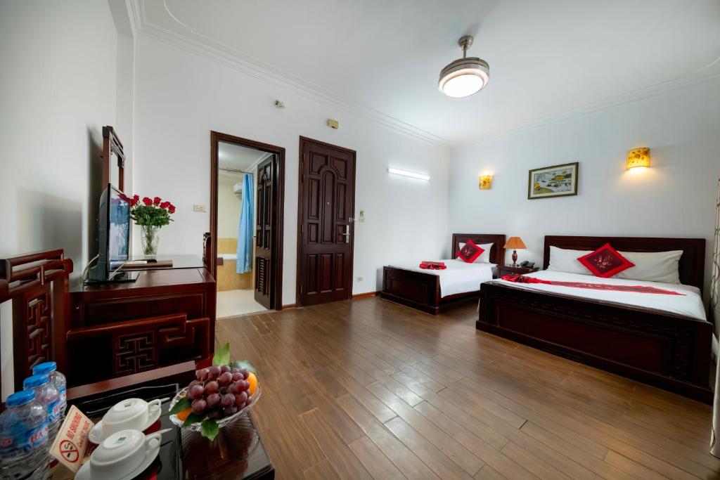 Cette chambre comprend deux lits et une table avec de la nourriture. dans l'établissement Phoenix Legend Hotel, à Hanoï