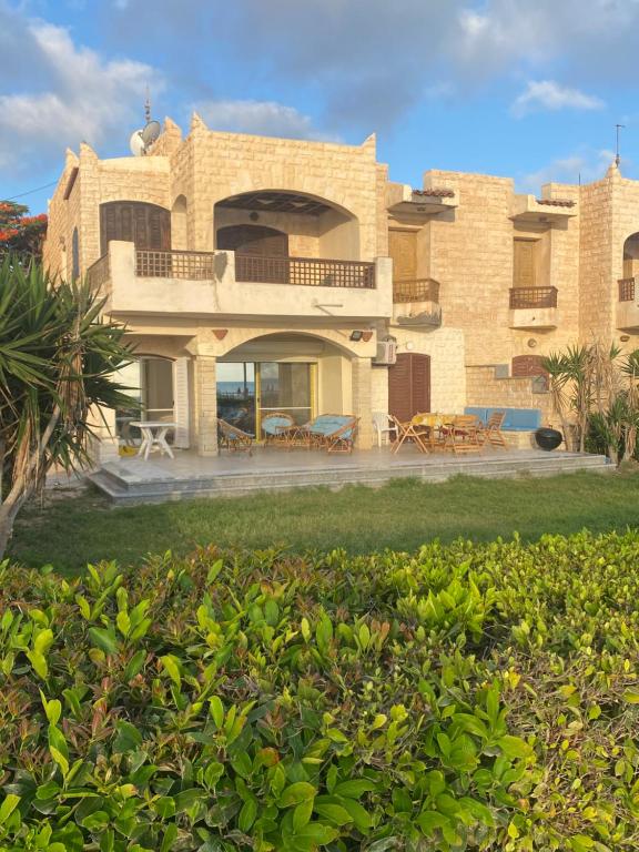 a large brick house with a lawn in front of it at Chalet Marina Alamein first row sea view 3 bedroom-North Coast in El Alamein