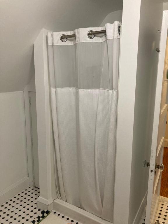 a shower with a white shower curtain in a bathroom at 9 Booth Lane in Haverford