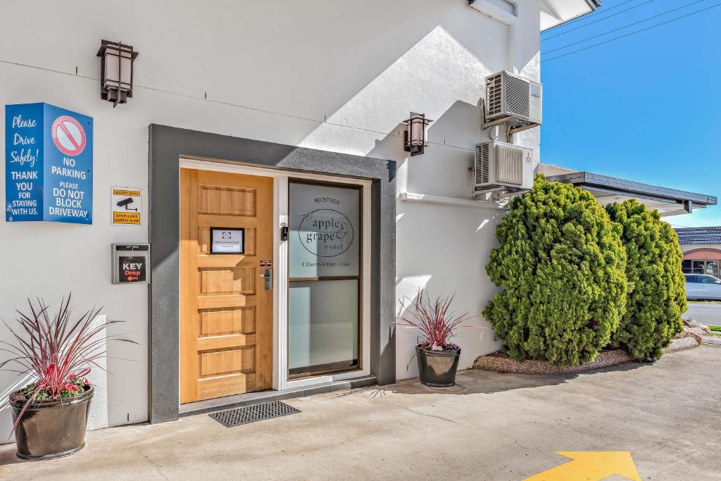 una puerta a un edificio con plantas delante de él en Apple & Grape Motel, en Stanthorpe