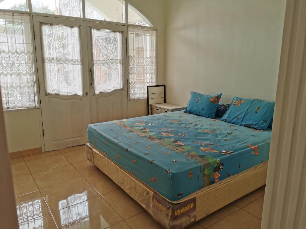 - une chambre dotée d'un grand lit avec des draps bleus dans l'établissement Wubao Villa dekat hotel Le Eminence Kota Bunga, à Cikundul