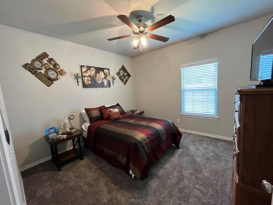 a bedroom with a bed and a ceiling fan at ComfyStay in Gladewater