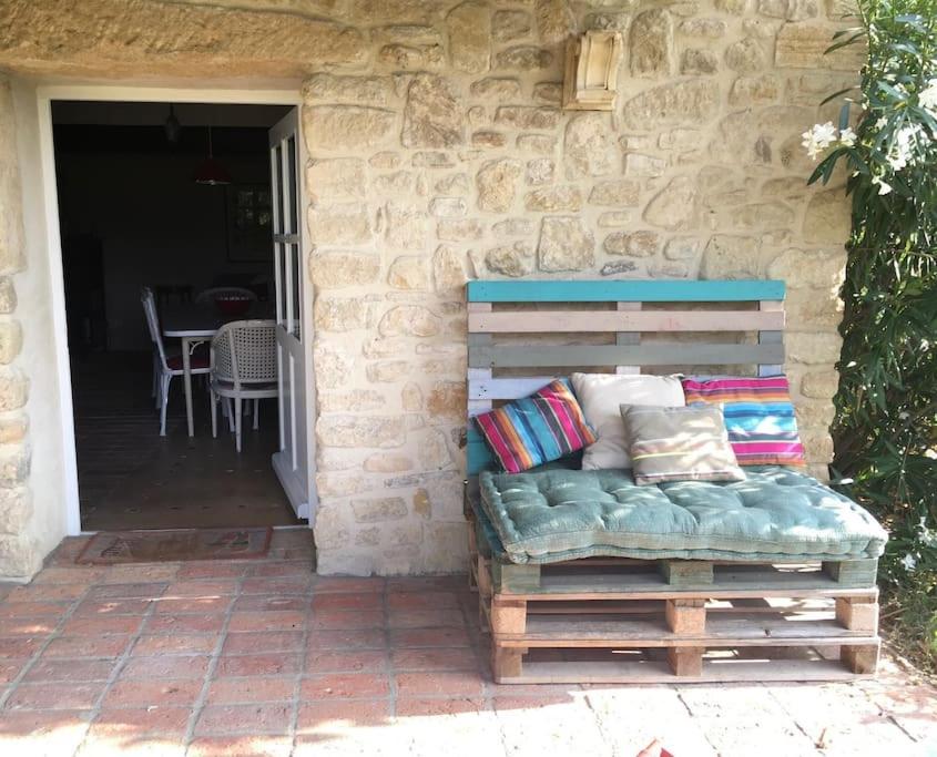 a couch sitting outside of a stone house at Gite des amis Domaine de Mas Caron in Caromb