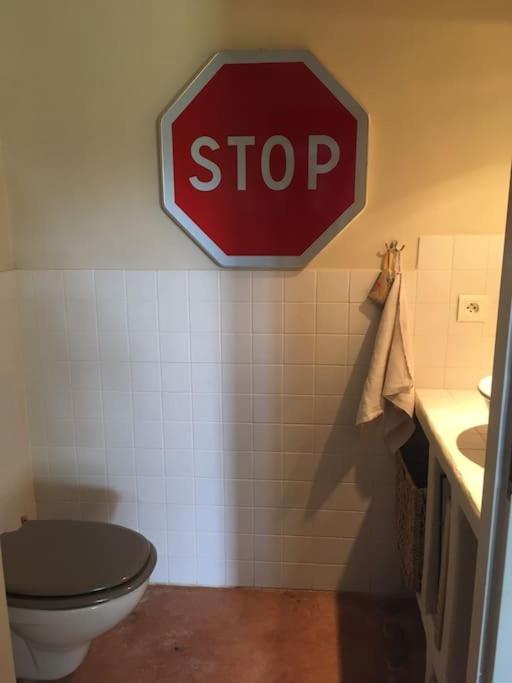 a stop sign in a bathroom with a toilet at Gite des amis Domaine de Mas Caron in Caromb