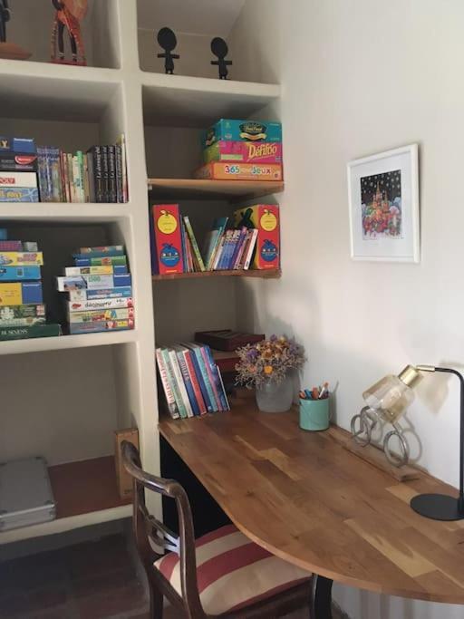 a room with a desk with a lamp and books at Gite des amis Domaine de Mas Caron in Caromb