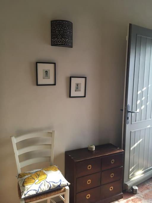 a bedroom with a chair and a dresser and a door at Gite des amis Domaine de Mas Caron in Caromb