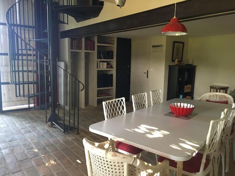 a dining room with a white table and chairs at Gite des amis Domaine de Mas Caron in Caromb