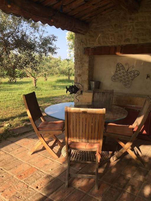 a patio with a table and chairs on a patio at Gite des amis Domaine de Mas Caron in Caromb