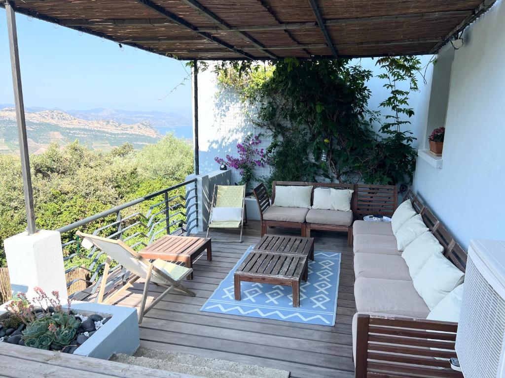 a deck with a couch and chairs and a table at Casa Costa in Barbaggio