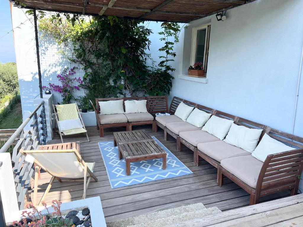 a patio with a couch and a table and chairs at Casa Costa in Barbaggio
