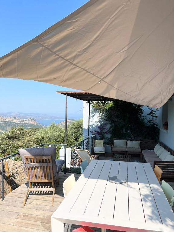 a patio with a table and a large umbrella at Casa Costa in Barbaggio